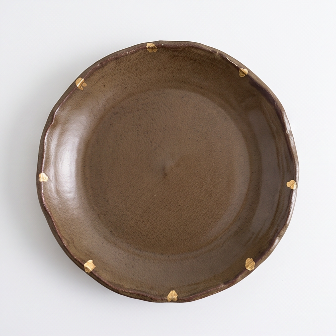Close-up of textured brown bowl rim with a gold-toned accent