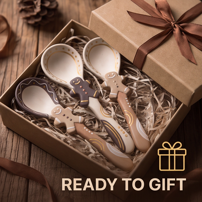 Four gingerbread-detail ceramic spoons arranged beside a wrapped gift