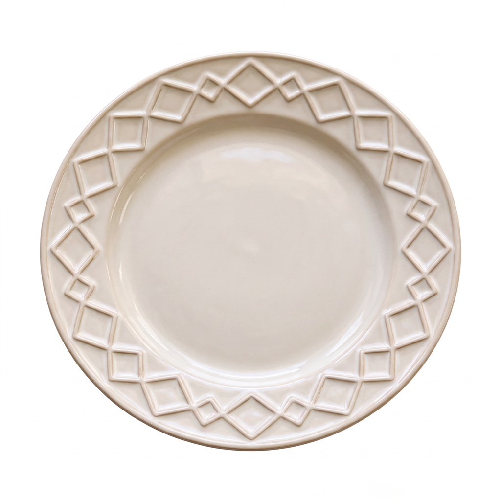 Cream serving plate with a raised geometric relief border, top-down view on a light background